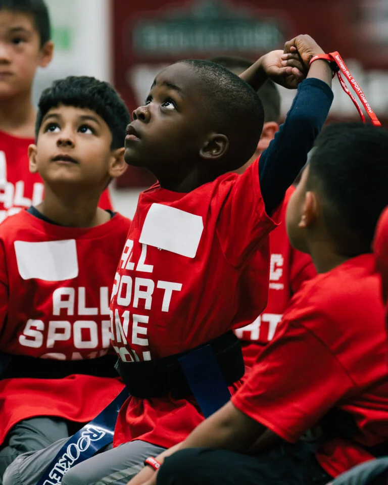 A young athletic kid stretches at a kids sport event
