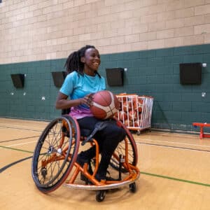 teenager in wheelchair plays basketball