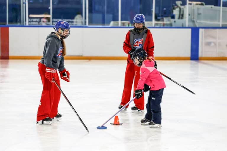 Coaches show ringette player how to improve stickhandling